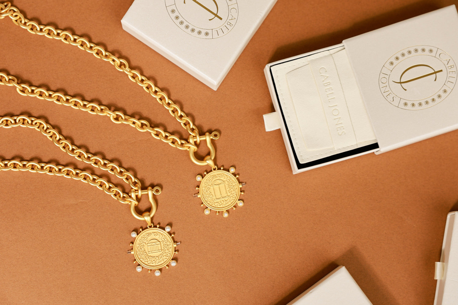 Gold necklace with pendant on a brown surface
