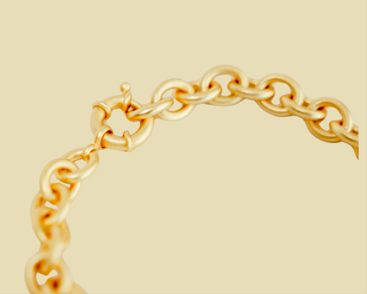 Gold chain necklace on a beige background